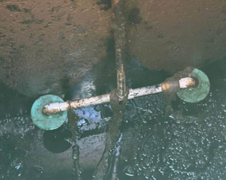 Pipe submerged in murky water.